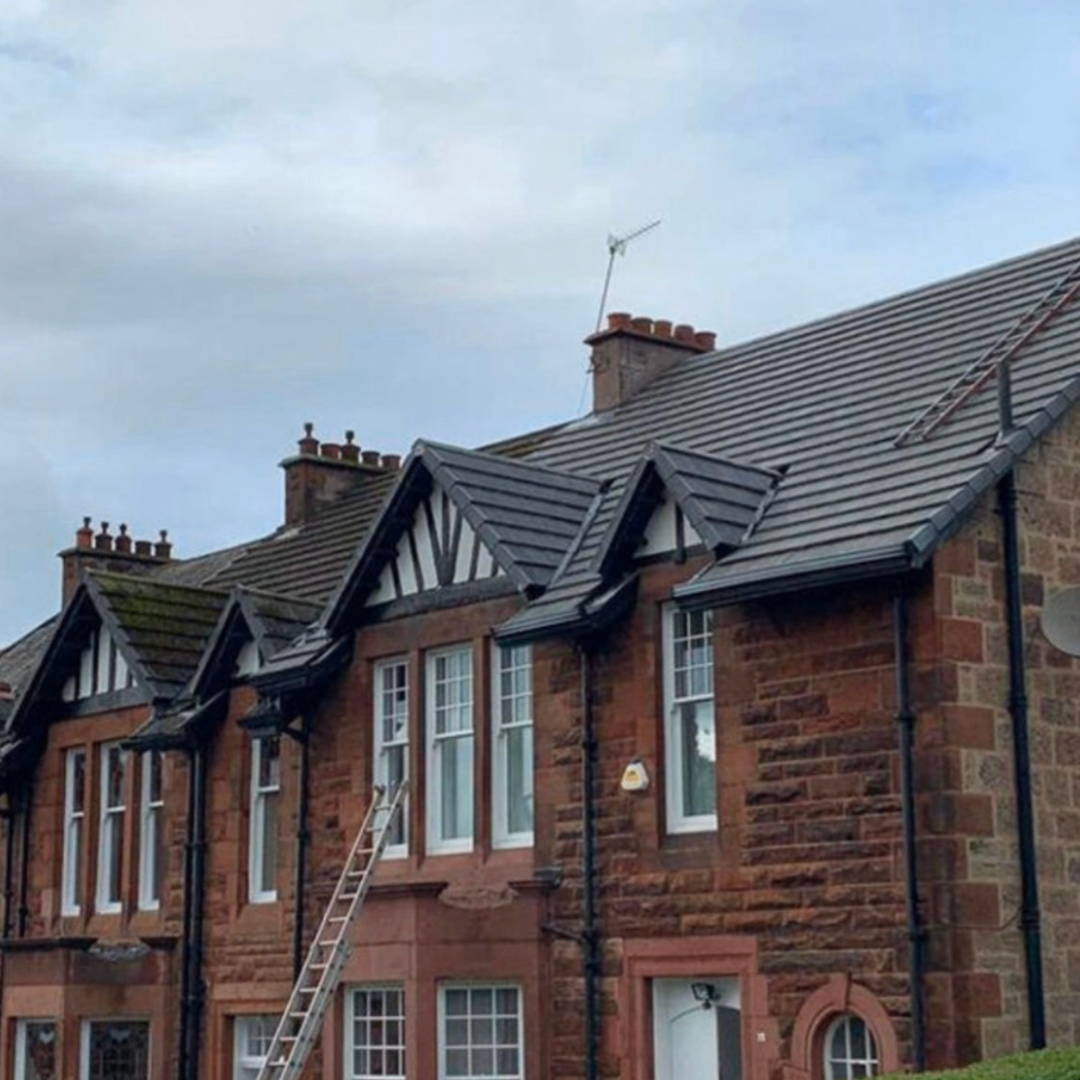 Completed grey tiled roof on a row of traditional homes